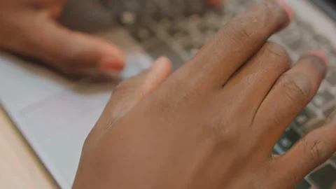 Black developer typing on laptop keyboard, closeup on fingers moving across keys Stock Footage 333183082