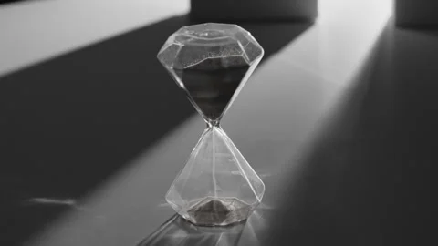 Black Diamond Shaped Hourglass Timer on Dark Surface Stockbeeldmateriaal 335142929