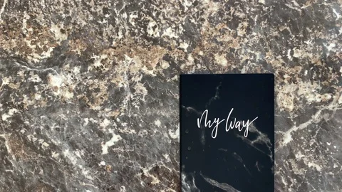Black diary on a black marble background Stock Footage 121253776