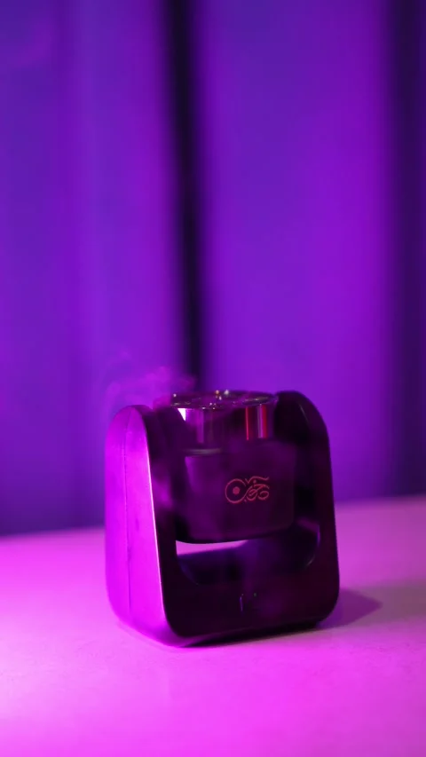 Black Diffuser Emitting Smoke Under Purple Studio Lighting Stock Footage 347824716