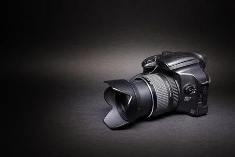 Black digital camera, full frame on a black background. Stock Photos