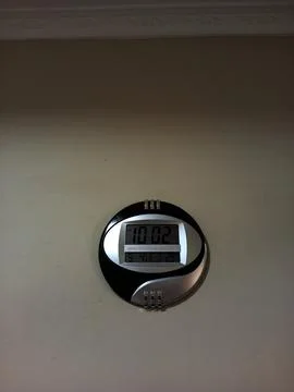 Black digital clock on a wall. Stock Photos