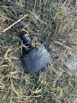 Black Discarded Plastic Part on Dry Grass Stock Photos