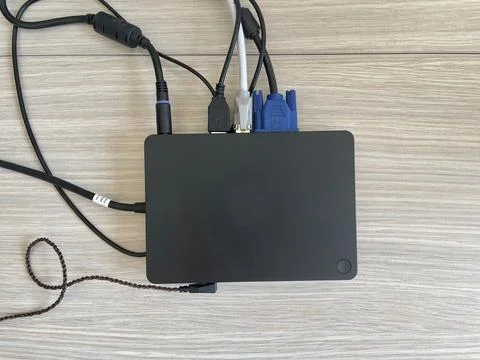 A black docking station with a various cables. Clean office desk and good cable Stock Photos