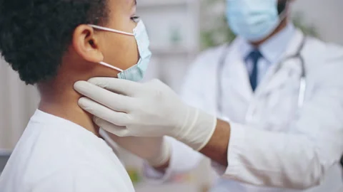 Black doctor checking lymph nodes of little patient, pediatrician examination Stock Footage 201145585