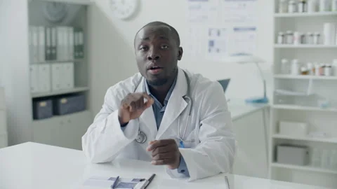 Black Doctor Talking at Camera during Virtual Consultation with Patient Stock Footage 313810339