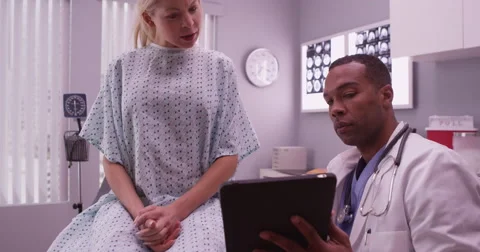 Black doctor talking with woman patient Stock Footage