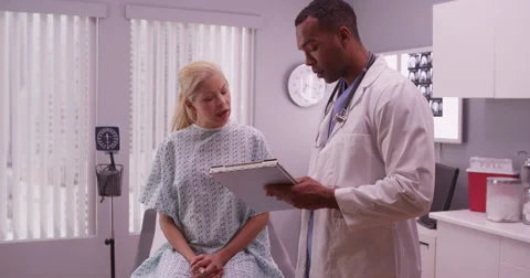 Black doctor writing down woman patient's medical history Видео 59677559