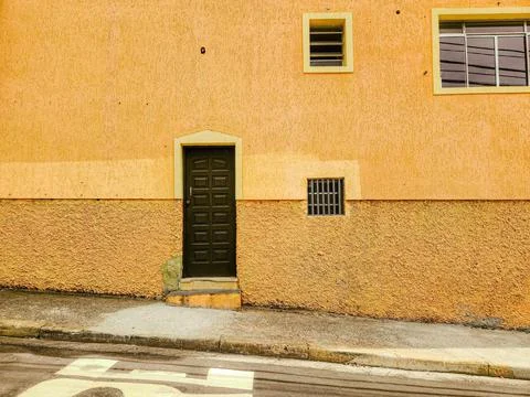 Black Door on Orange Wall Stock Photos