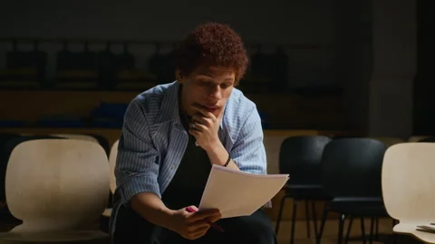 Black Drama Student Reading Script and Rehearsing in Auditorium Stock Footage 344518506