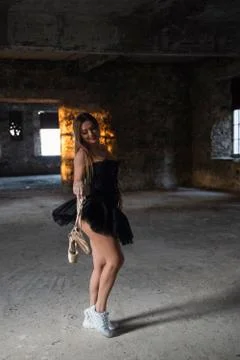 Black dressed ballet dancer posing in abandoned hotel building Stock Photos