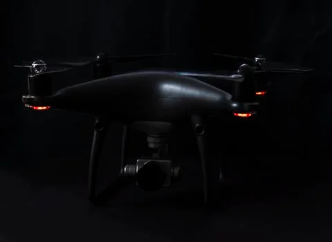 Black drone and silver camera on black background Stock Photos
