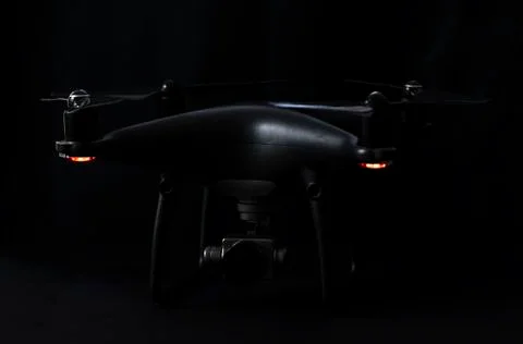 Black drone and silver camera on black background Foto stock