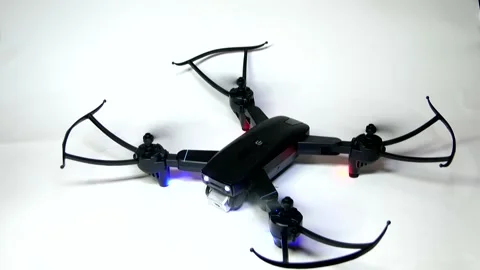 The black drone's four propellers are launched and the takes off into the air Stock Footage 342256802