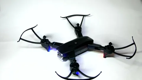 The black drone's propellers start to spin and the drone takes off. Stock-Footage 342256975