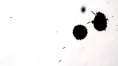 Black drops of black ink dropped on white plane Stock Footage 70342153