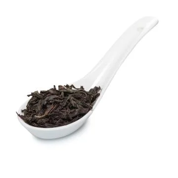 Black dry tea large leaf in the spoon Stock Photos