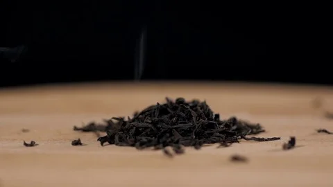Black dry tea leaves isolated on black background pouring down Stock Footage