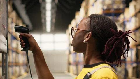 Black e-commerce employee scanning awb tracking numbers Stock Photos