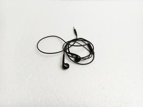 Black Earbuds With Tangled Cable on White Background Fotos de archivo