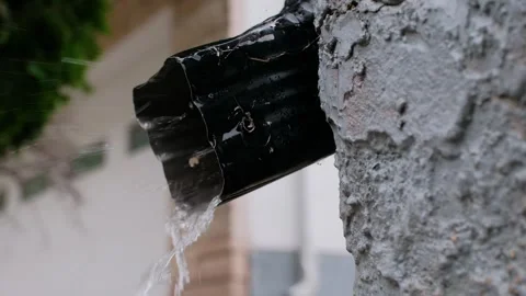 Black Eavestrough Outlet with Rain Pouring Out on Rainy Day Video Video stock 344070174