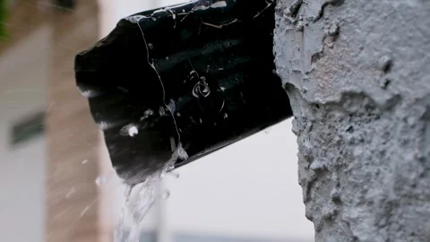 Black Eavestrough Outlet with Rain Pouring Out on Rainy Day Video Video stock 344070235