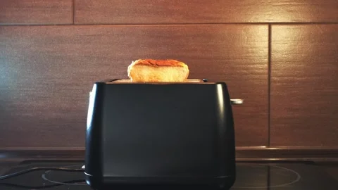 Black electric toaster toasting bread slices in kitchen Stock Footage 340879880