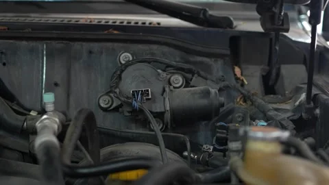 A black electric windshield wiper motor assembly with electrical connectors a Stock Footage 345110508