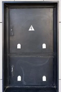 Black electrical panel with warning sign on urban wall Stock-Fotos