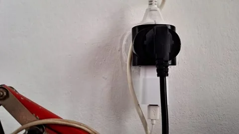 Black Electrical Plug Adapter Connected to Wall Outlet Indoors Vídeos de archivo 348486840