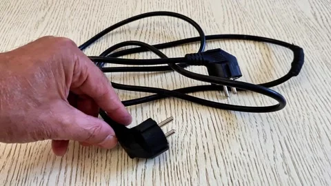 Black Electrical Power Cord with Two Plug Ends on Wooden Surface Stock Footage 340746746