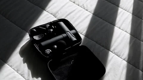 Black electronic accessories in a compact case are arranged on a textured white Stock Footage 325139176