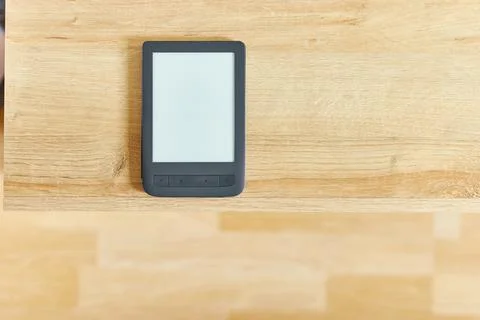 Black electronic book with empty screen on wooden table and free space for ad Foto stock