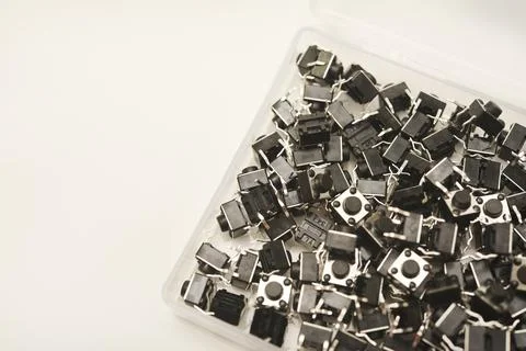 Black electronic buttons in a plastic container. Electronic elements. 스톡 사진