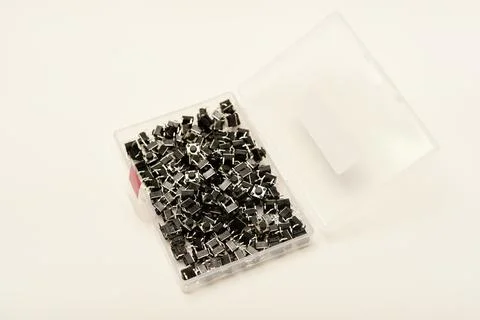 Black electronic buttons in a plastic container. Electronic elements. 스톡 사진
