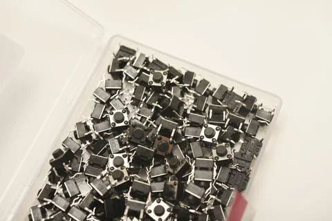 Black electronic buttons in a plastic container. Electronic elements. Stock-Fotos