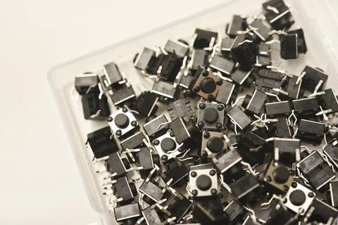 Black electronic buttons in a plastic container. Electronic elements. 스톡 사진