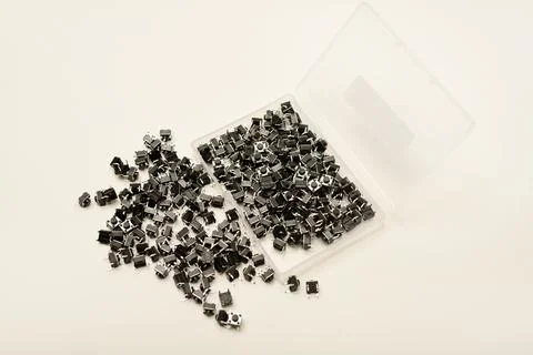 Black electronic buttons in a plastic container. Electronic elements. Stock-Fotos