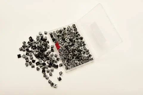 Black electronic buttons in a plastic container. Electronic elements. 스톡 사진