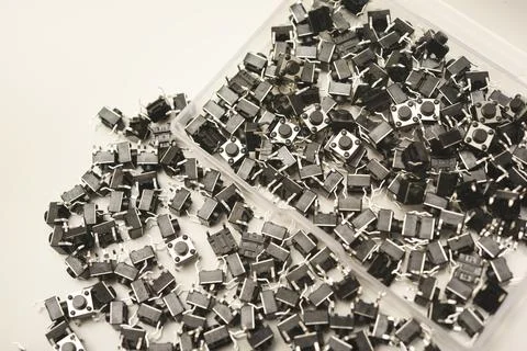 Black electronic buttons in a plastic container. Electronic elements. 스톡 사진