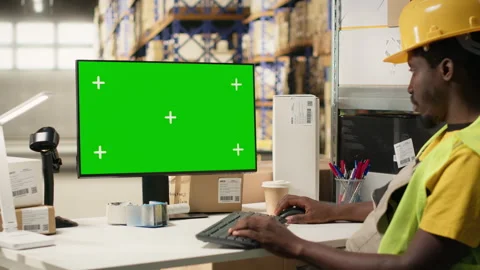 Black employee in depot setting looking at copy space screen on pc Video stock 315540189