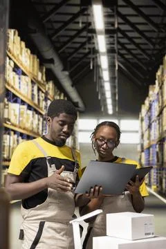 Black employees checking inventory and shipment details on laptop Stock Photos