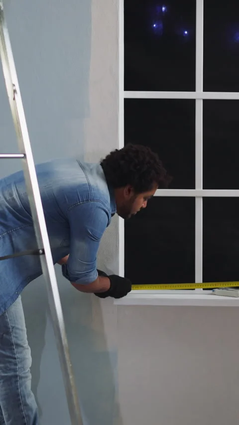 Black employees measure window width with retractable tape Stock Footage 309878067