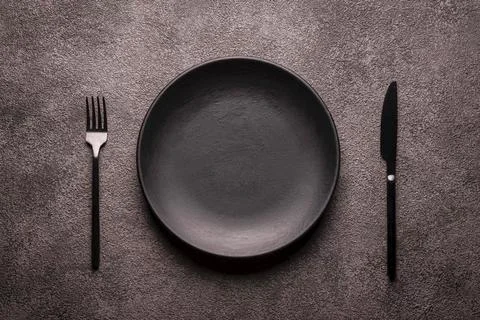A black empty mocap plate on a gray textured background and cutlery, fork and Foto stock