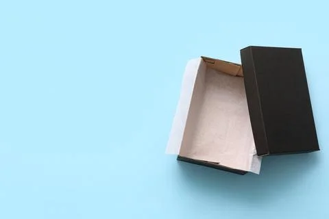 Black empty shoebox on blue background Stock Photos