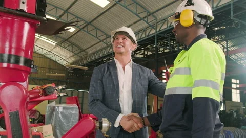 Black engineer handshakes with customer with robotic arm in a smart factory. Stock Footage 229230325