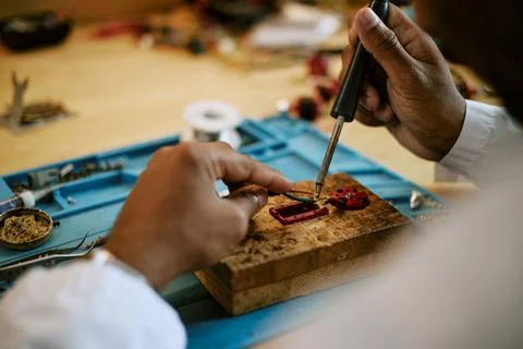 Black Engineer Soldering Electronic Components in Laboratory Stock Photos