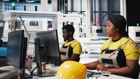 Black engineer testing solar technology at desk in renewable energy facility Stock Footage 309072199