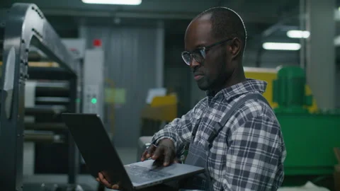 Black Engineer Using Laptop to Program Automated Machinery in Printing Factory 스톡 동영상 335483696