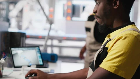 Black engineer works on solar software settings in automated factory Stock Footage 309070925